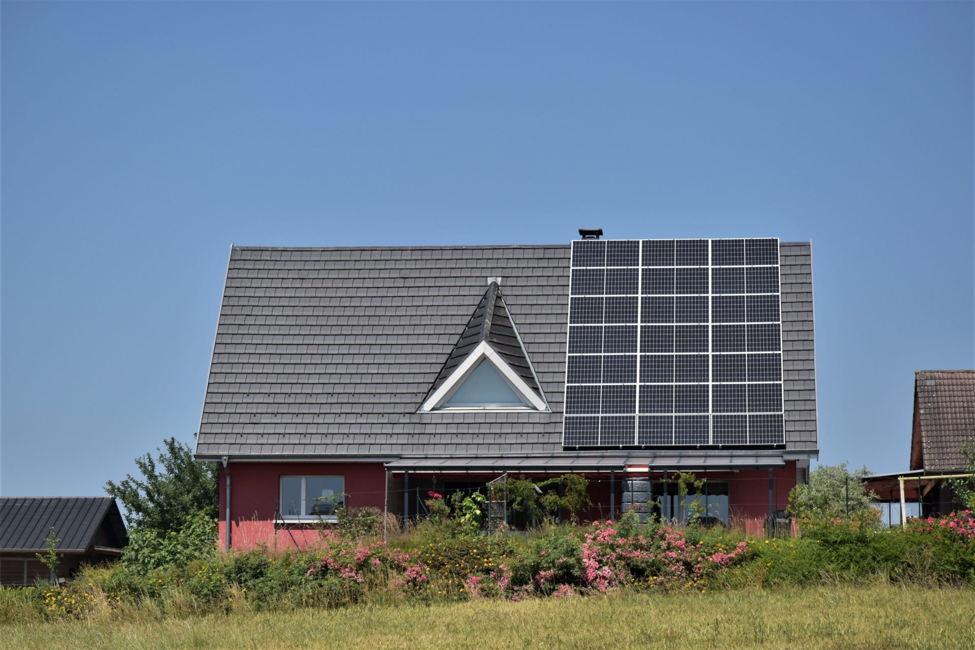 Half of the pitched roof of a detached house is covered with solar panels.