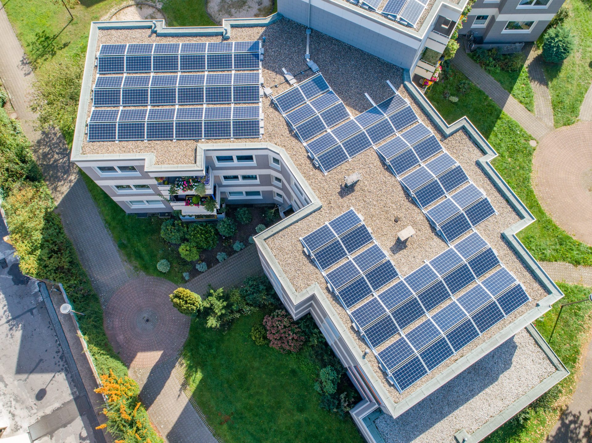Solar panels on the roof of an apartment building, taken from the air.
